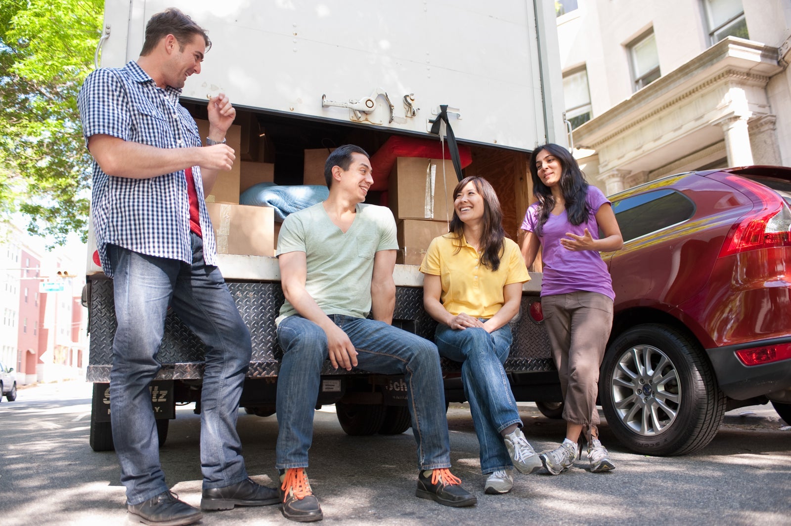 Young Adult Friends at the back of moving truck