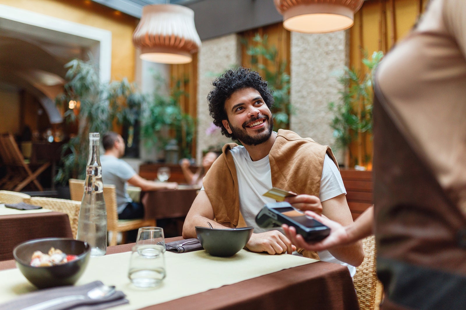 Young Man Paying for Meal at Restaurant