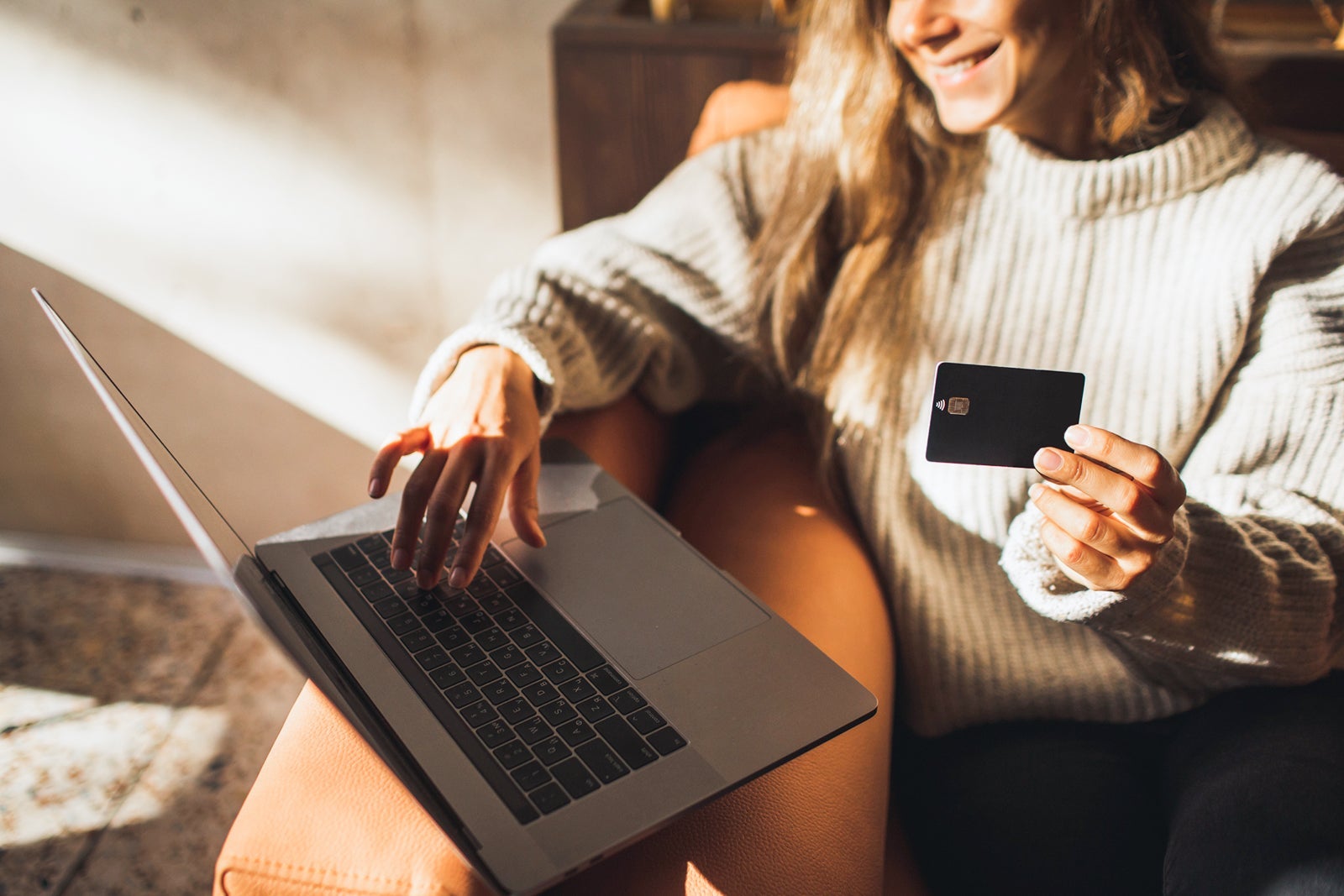 Woman hand holding credit card and making online purchases in internet in Cafe with Laptop. Unrecognisable person