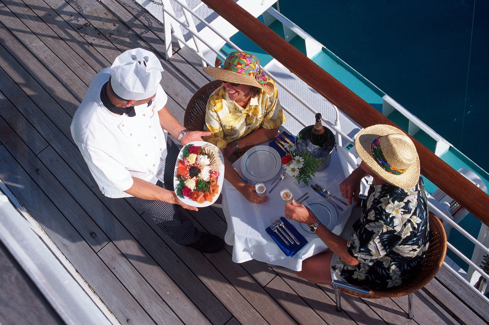 couple receiving meal on deck of passenger liner