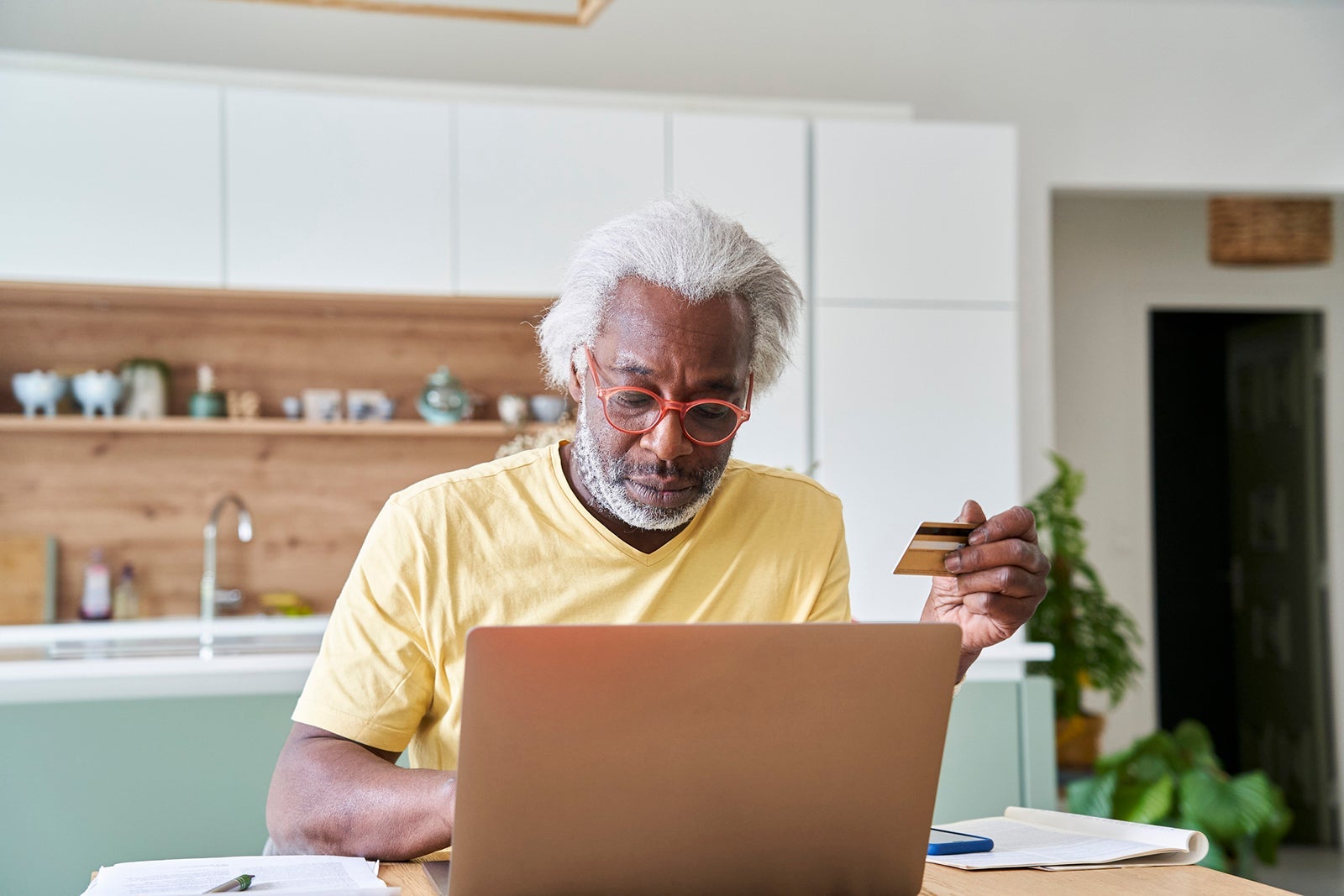 Senior man using laptop and credit card
