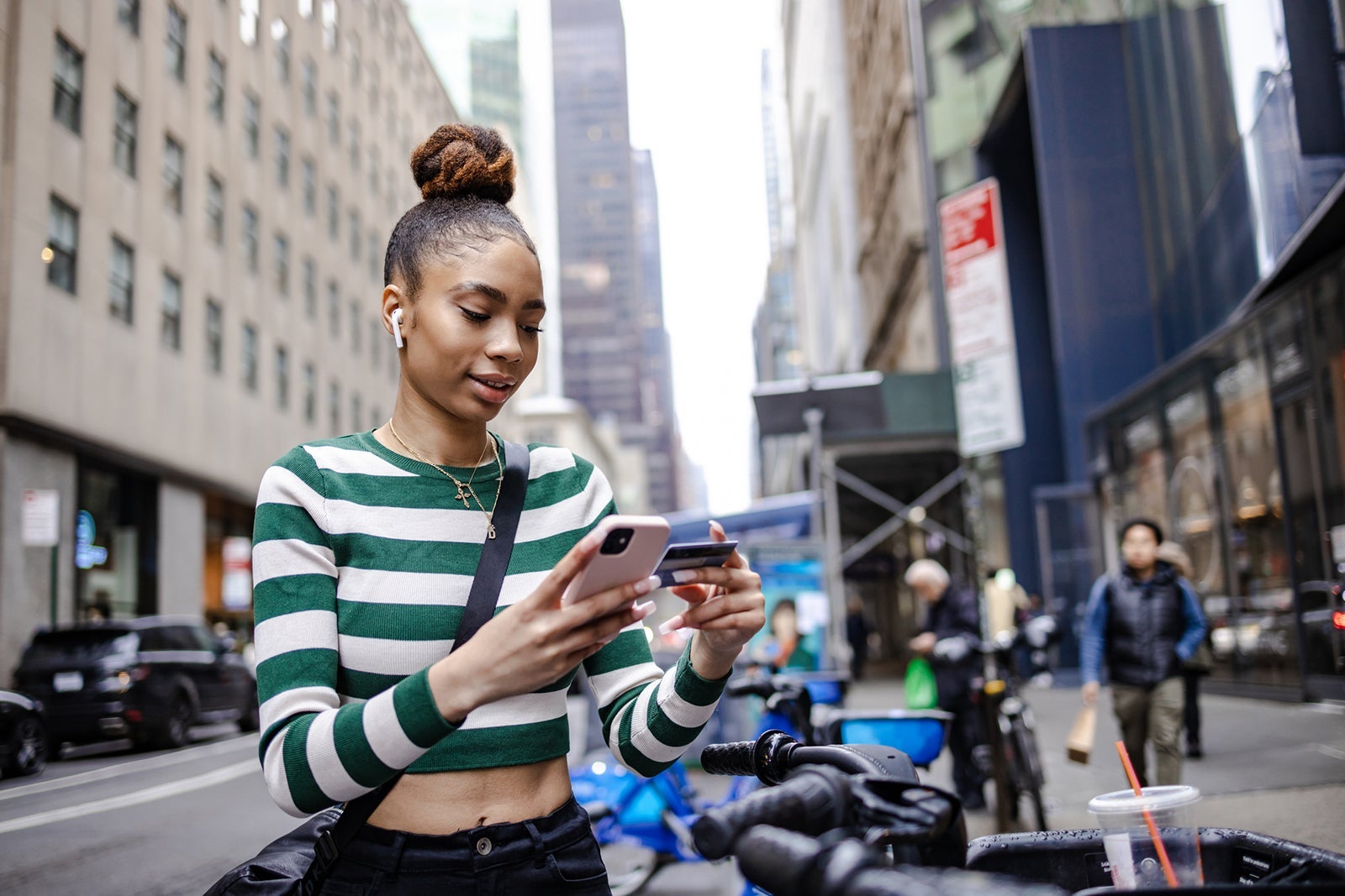 Young woman using smart phone to rent sharing bike