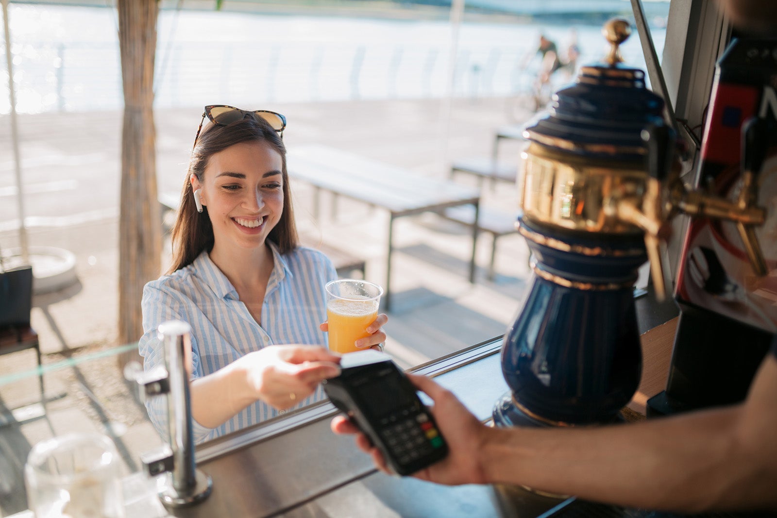Attractive young Caucasian woman paying for a drink with a credit card