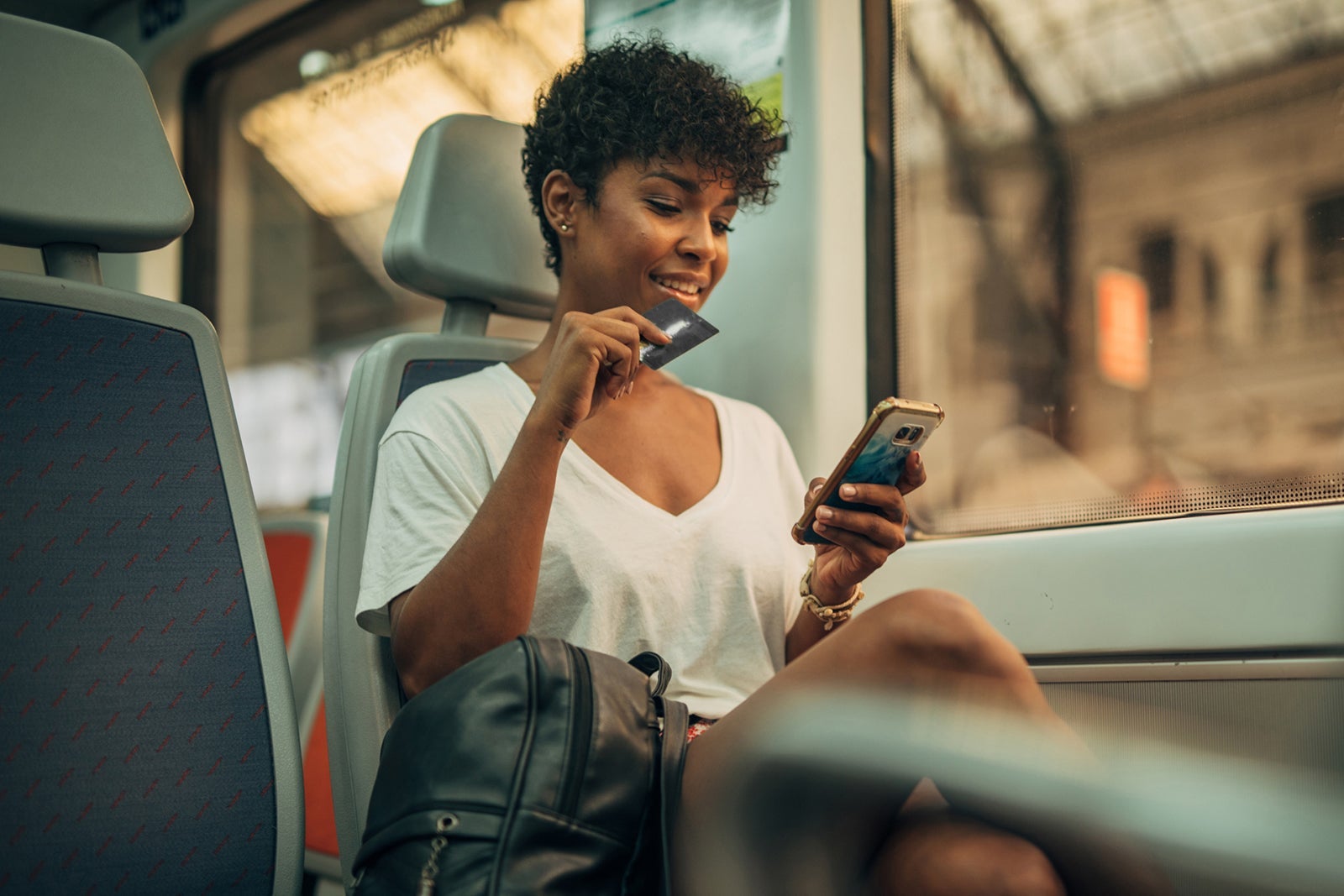 Young woman using mobile in train