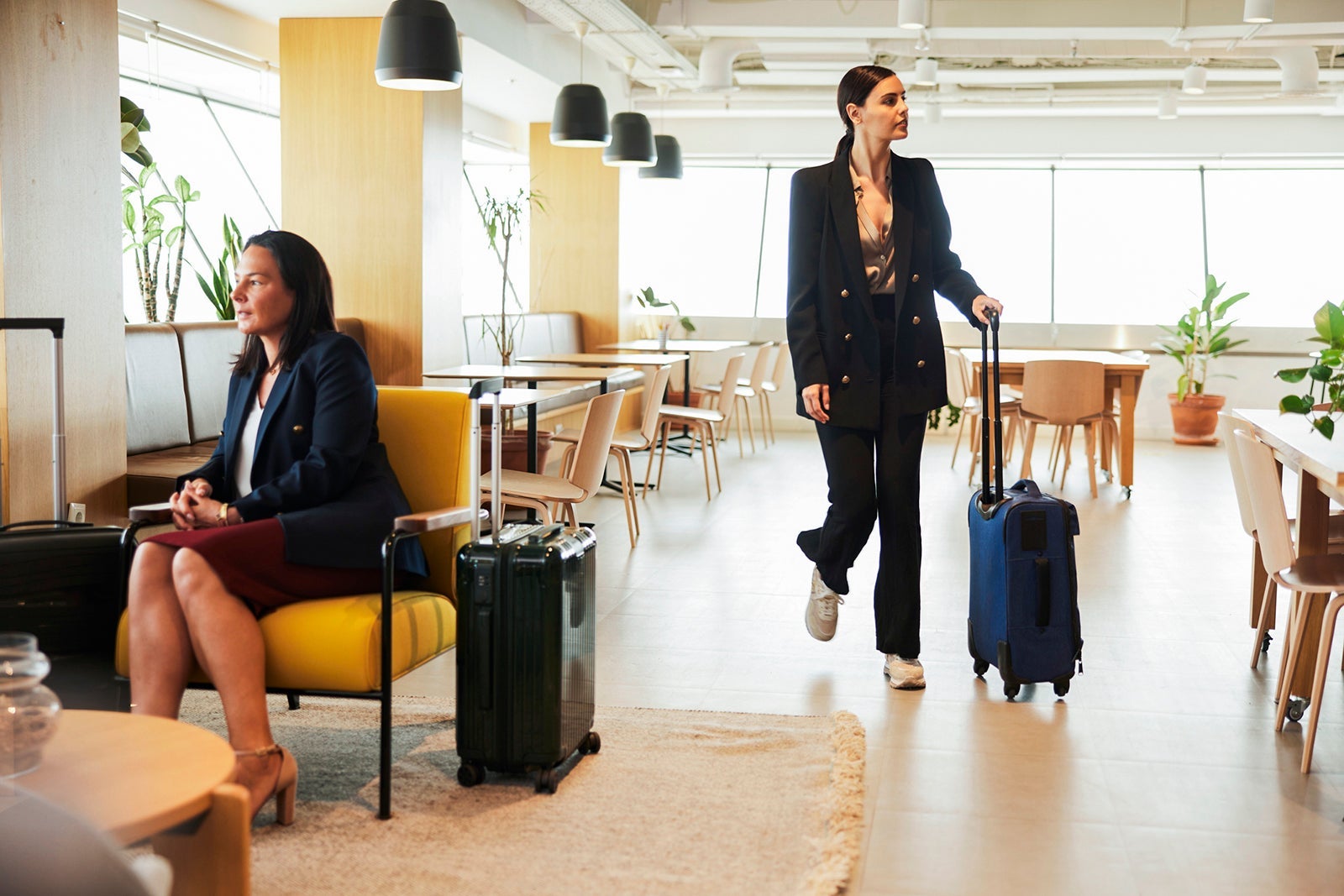 Dynamic Airport Scene: Businesswoman Traveler Moving Amidst Seated Professionals in VIP Lounge