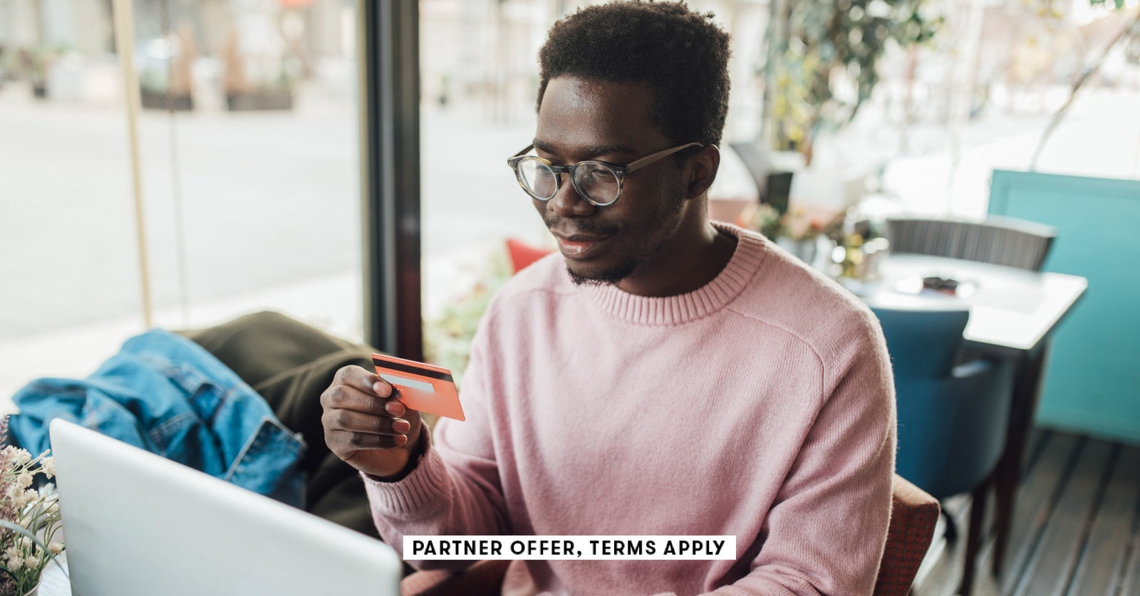 Portrait of a young African American enjoying at the cafe buying something online