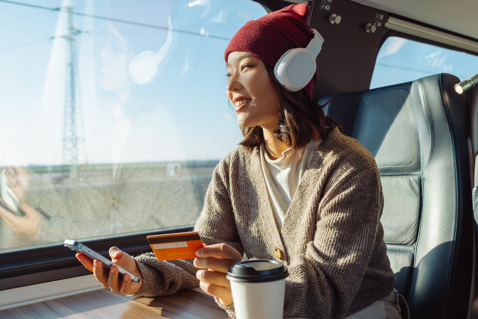 Young Asian woman using online payment services on smart phone in train. Easy paying
