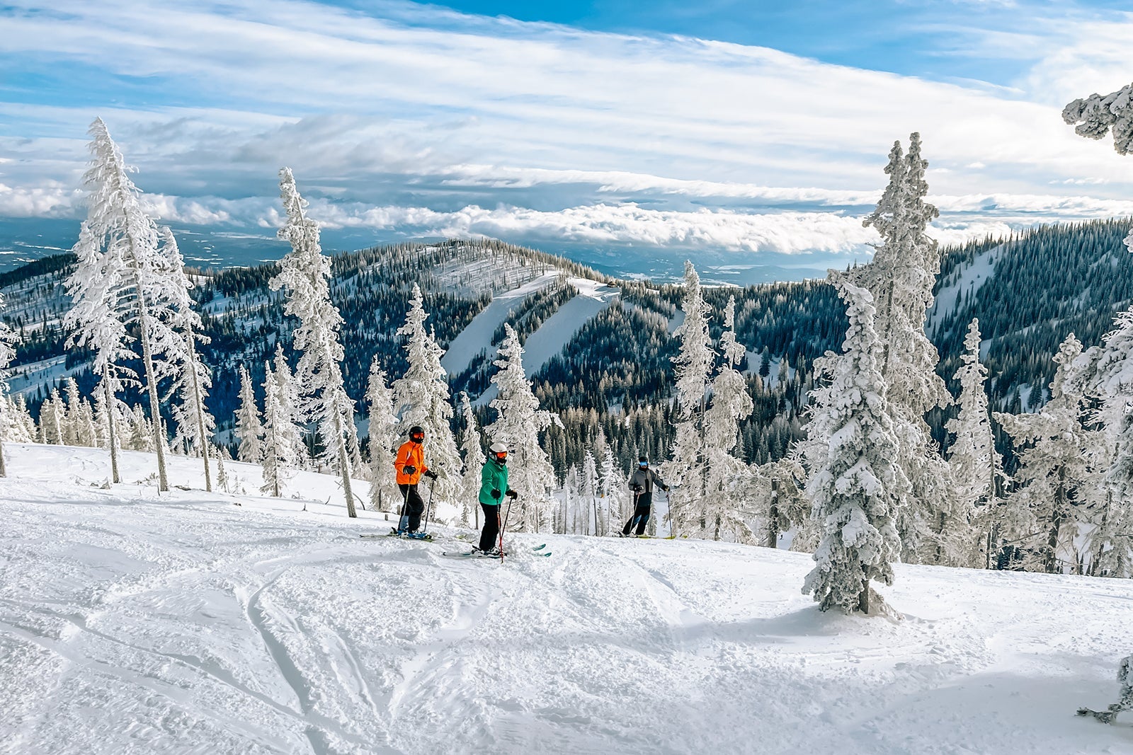 3 skiers on a ski slope in a beautiful snow mountain landscape at Schweitzer Mountain, Idaho.