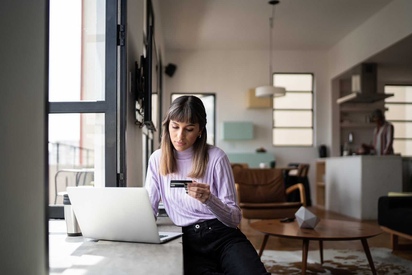 Young woman doing online shopping using credit card at home