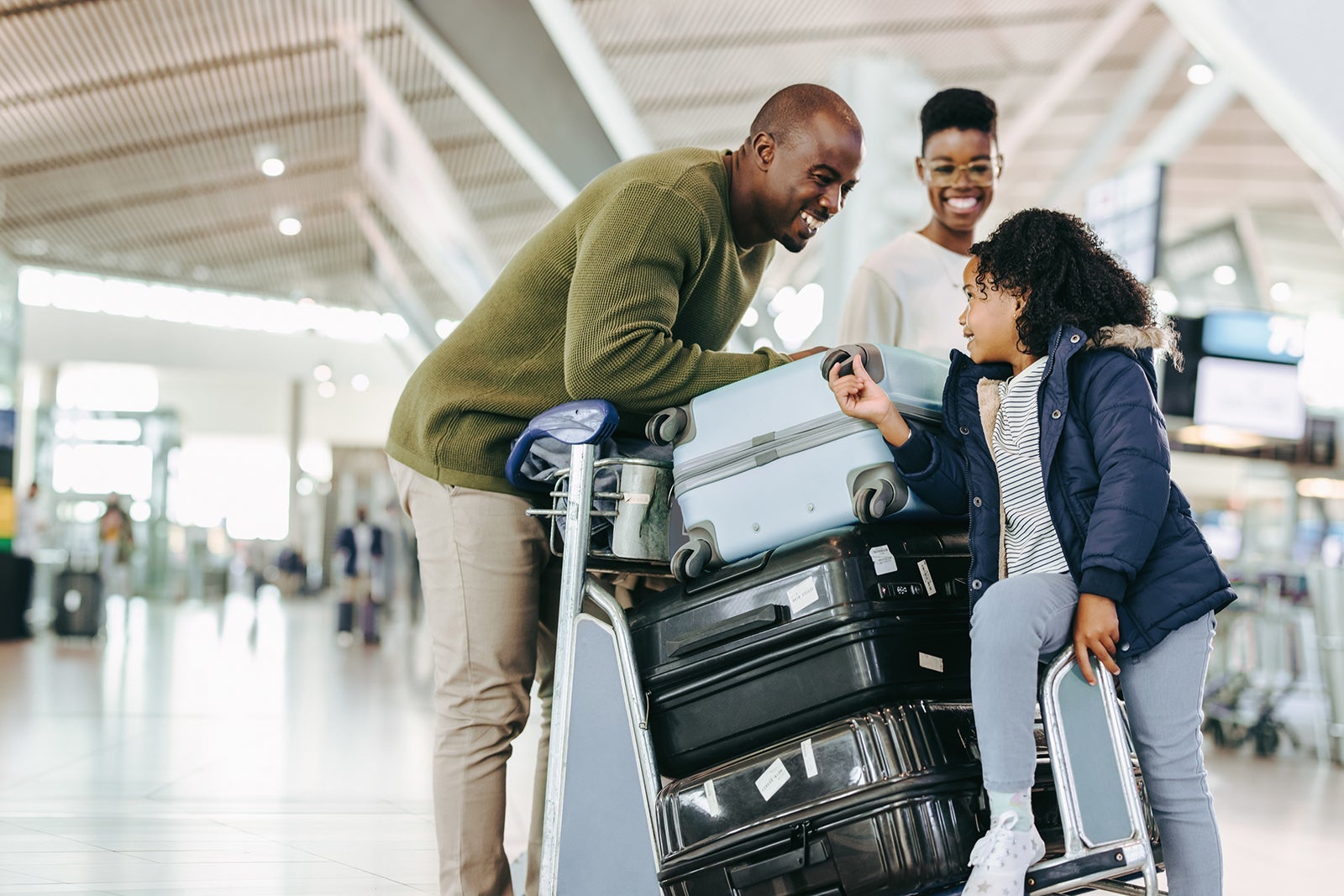 Tourist family with luggage trolley at airport