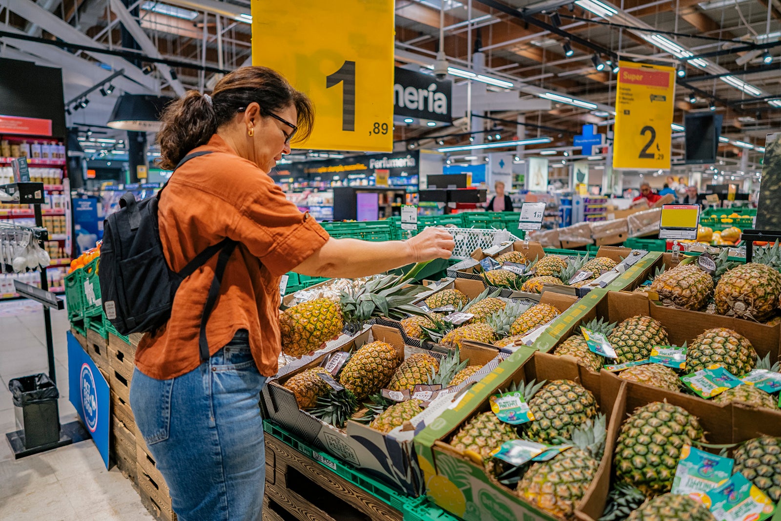 Woman buying at the supermarket. Choosing tropical fruits at the groceries store. Woman buying at the supermarket. Discount and sale or wholesale promotion of healthy food. Customer or consumerism