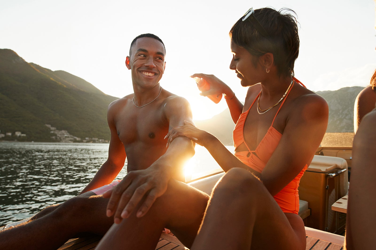 Woman applying sunscreen on boyfriend's arm