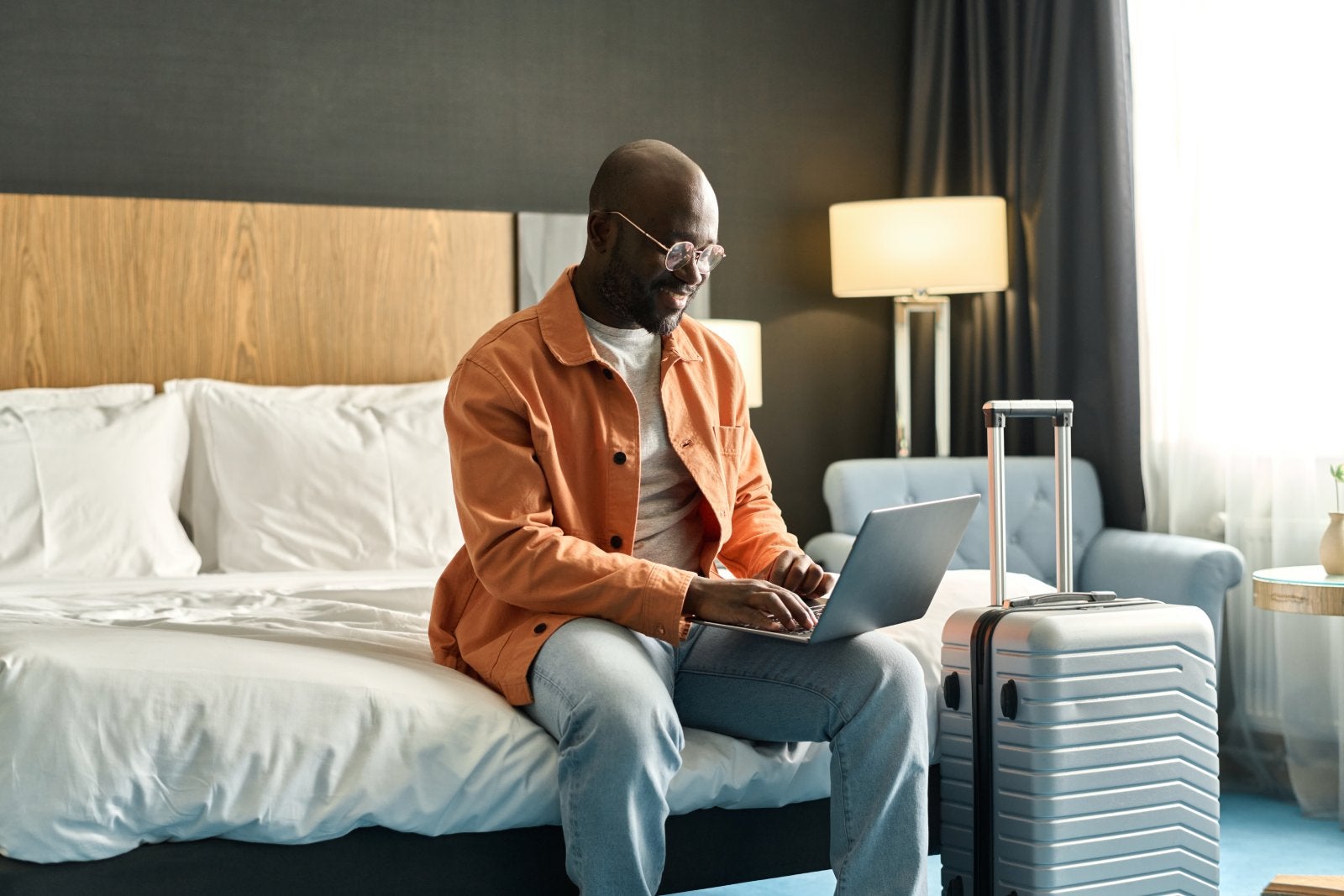 Black Man using Laptop in Hotel Room